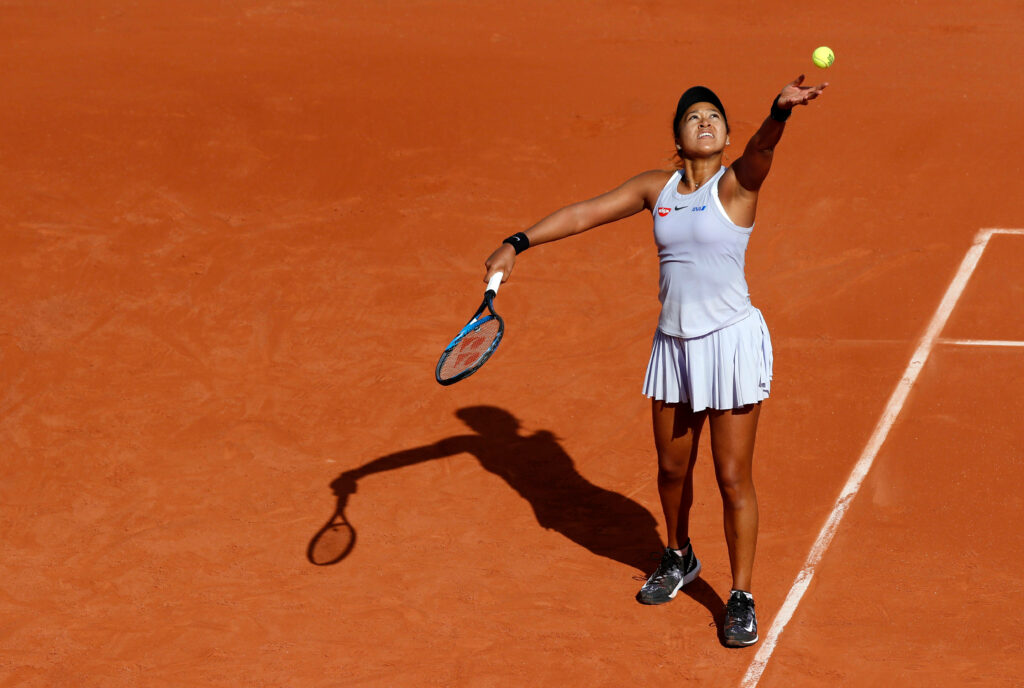Naomi Osaka Serving on Clay Court – Tennis Wallpaper Background