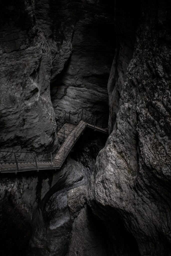 Winding narrow staircase carved into towering gray rock walls in rugged mountain gorge wallpaper