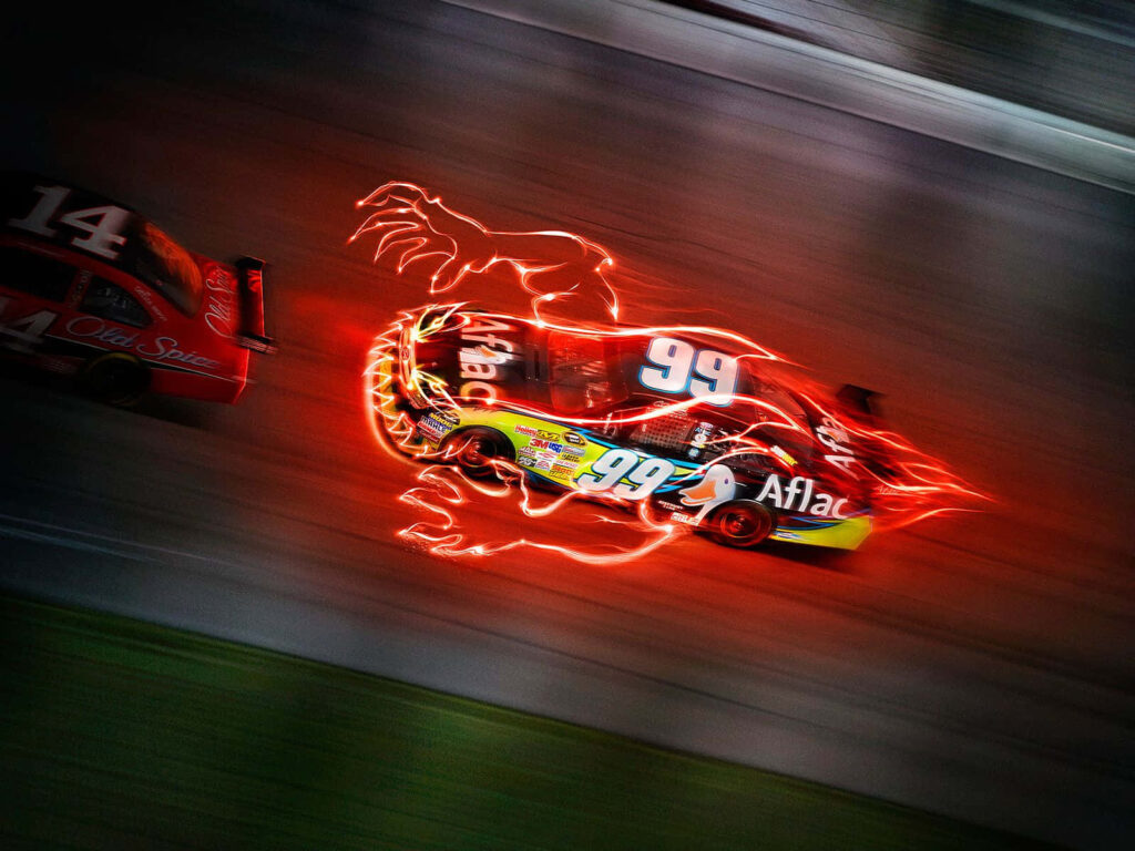Nascar race car number 99 speeding with vivid red light trails creating intense motion effect Wallpaper