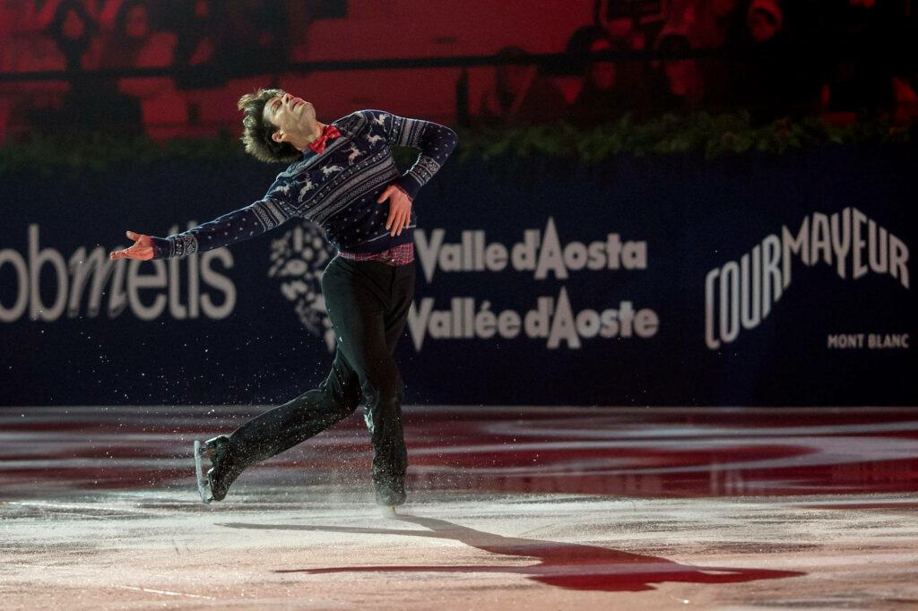 Figure Skating Champion Nathan Chen gracefully glides on ice showcasing athleticism and artistry Wallpaper