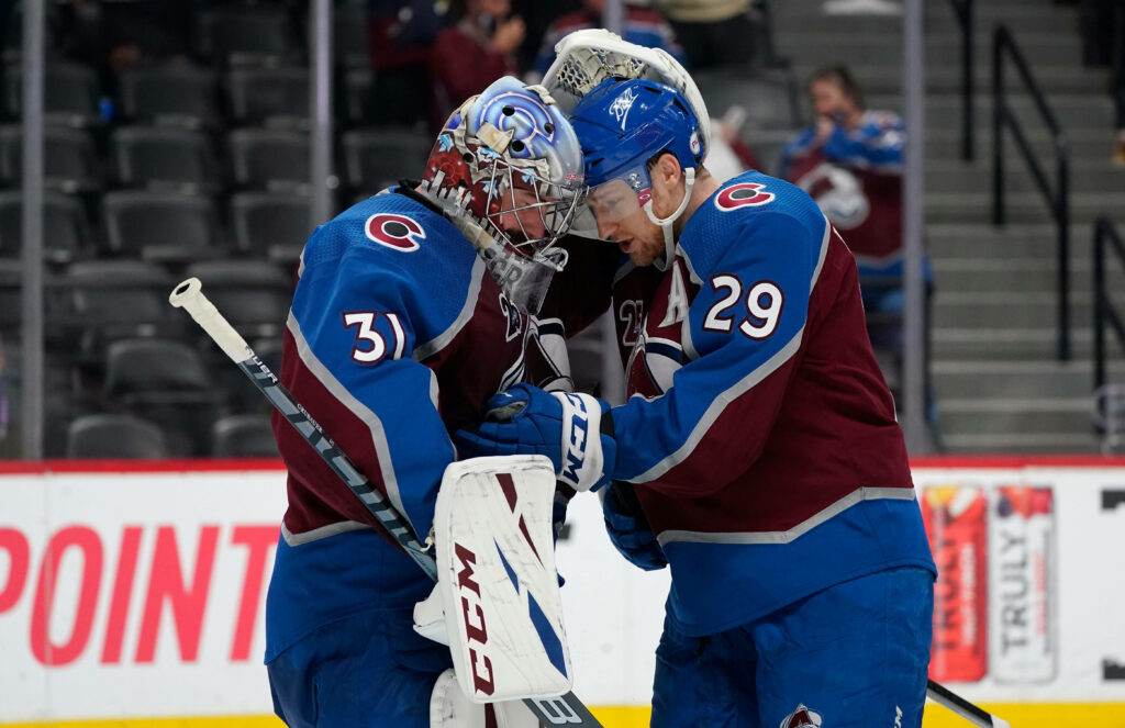 Nathan MacKinnon and Philipp Grubauer celebrate on ice Colorado Avalanche team spirit wallpaper background