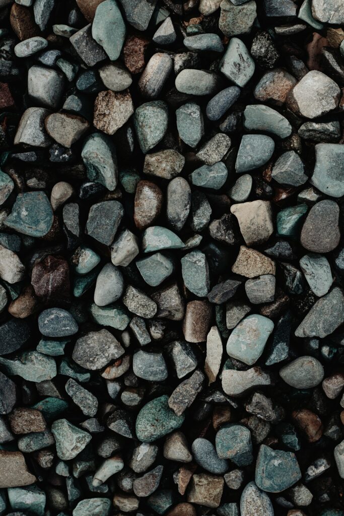 Close-up of assorted pebbles gravel and granite showing natural textures and earth tones wallpaper
