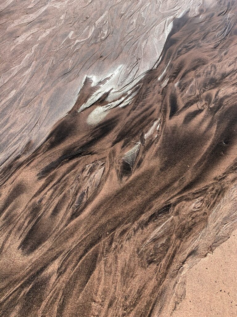 Close-up of natural sand erosion patterns with brown and beige textures wallpaper background