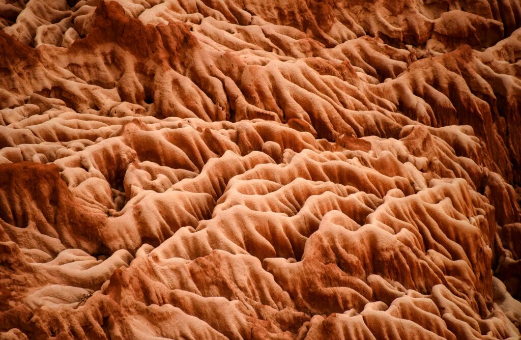 Intricate sand formations with layered earthy tones and mineral textures in natural landscape wallpaper