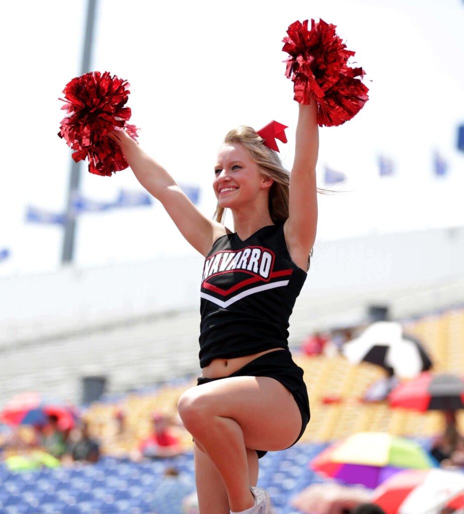 Dynamic Navarro College Cheerleader Routine with Red Pom-Poms Wallpaper