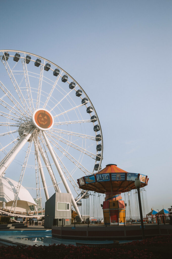 Navy Pier Ferris wheel and colorful phone swinger ride under bright blue sky vibrant amusement park Wallpaper