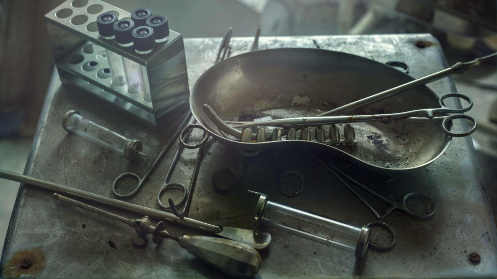 Dusty Relics: A Pile of Neglected and Filthy Medical Instruments on a Rusty Metal Table Wallpaper