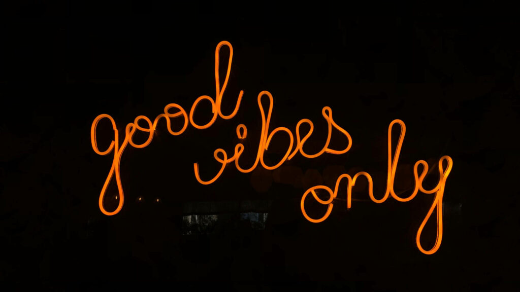 Neon Sign of Positivity in a Dark Room Wallpaper