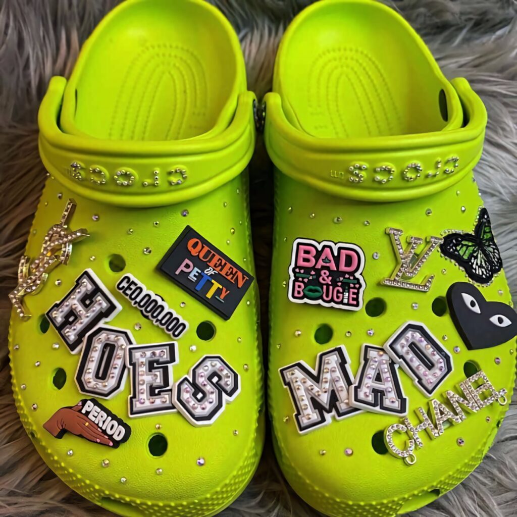 Neon green clogs with bold stickers and pins on textured surface vibrant playful wallpaper background