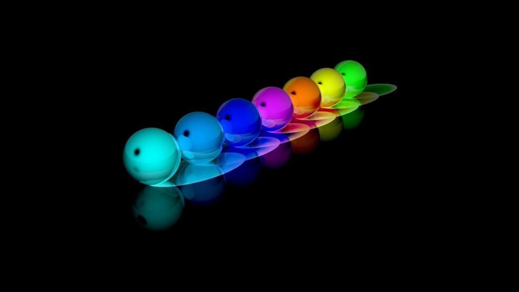Glossy neon rainbow spheres in a diagonal row on a reflective black background digital wallpaper