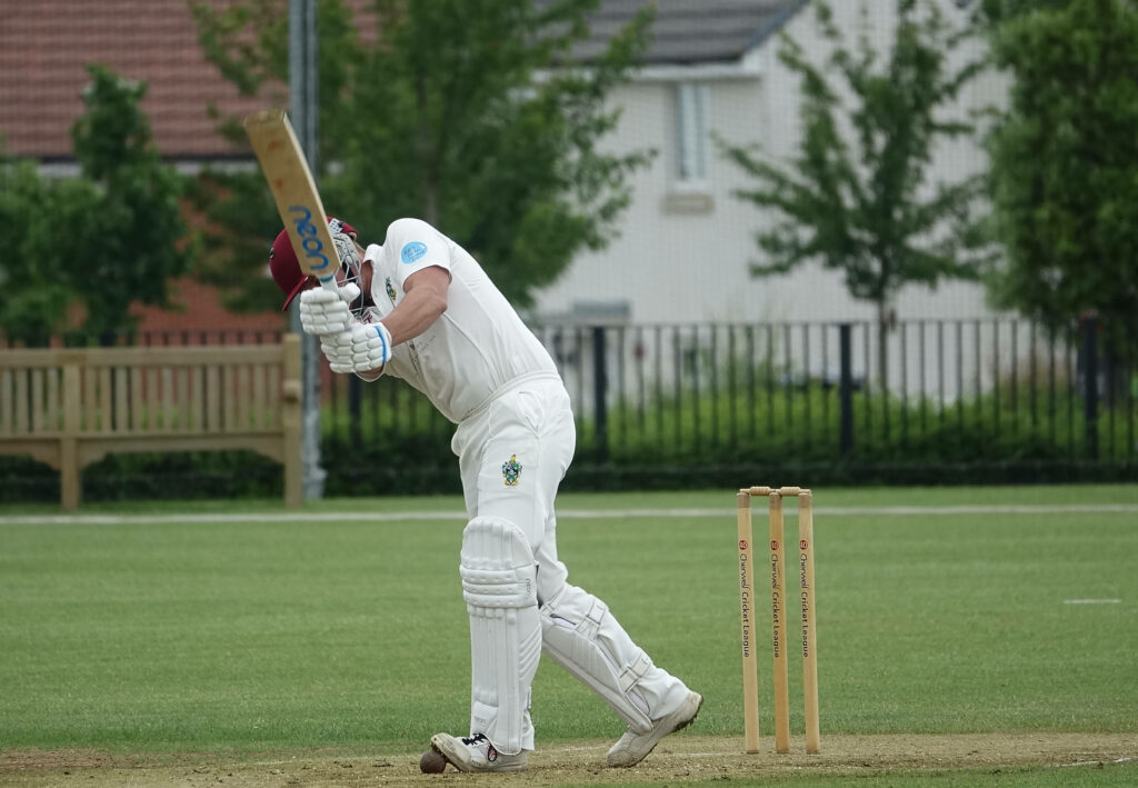 Neon-Printed Power: A Striking Cricketer in Action Wallpaper