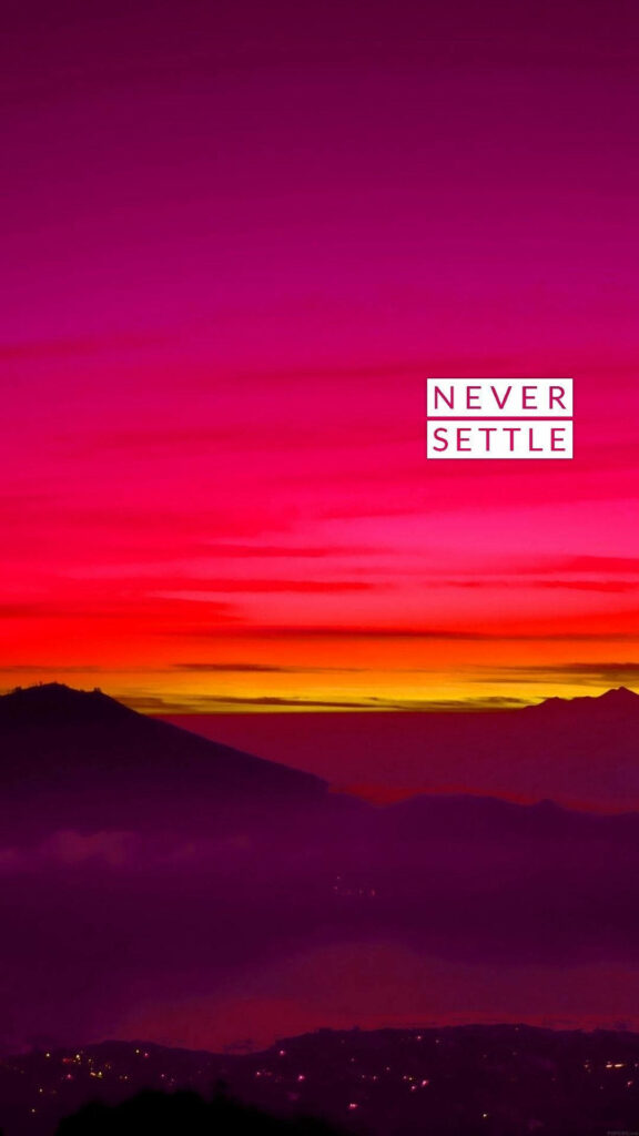 Breaking Barriers: Oneplus 'Never Settle' Dusk Wallpaper Captures Mountain and City Silhouettes Against Vibrant Pink Sky