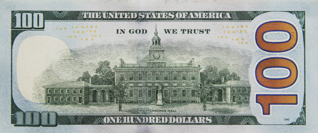 High-resolution U.S. 100-dollar bill reverse with Independence Hall and orange 100 on blue background Wallpaper