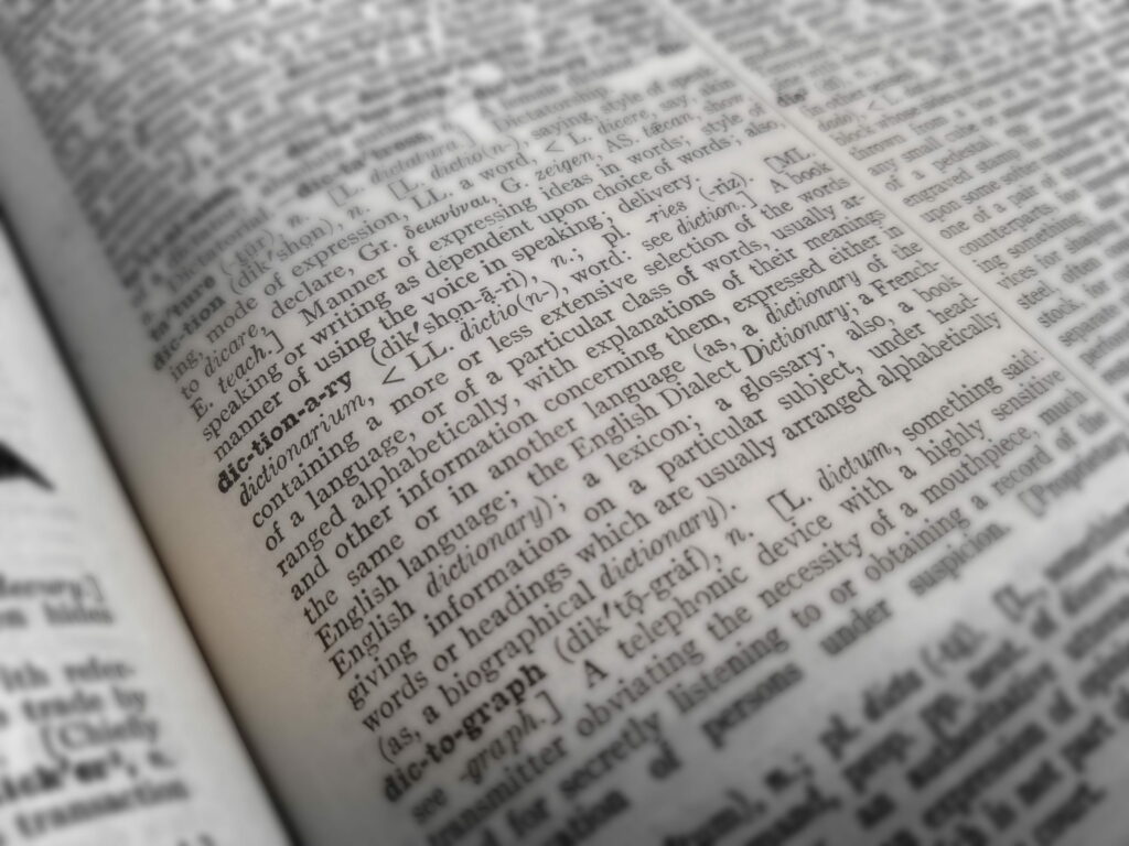 Close-up vintage dictionary open page with sharp text and soft blurred edges monochrome wallpaper
