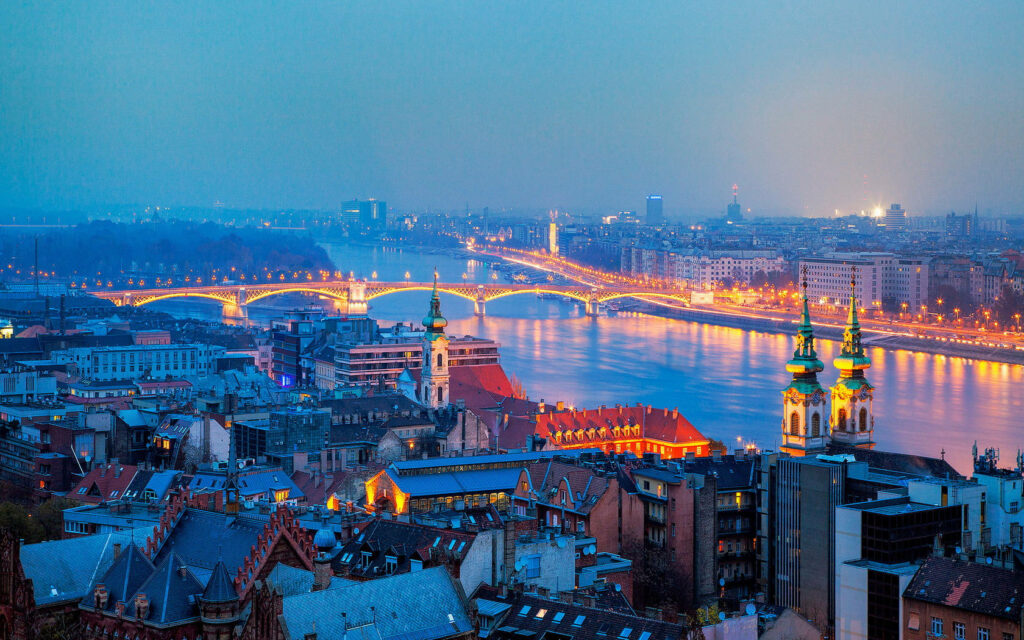 Danube Delights: A Mesmerizing Nighttime Portrait of Hungary's Iconic River, Embraced by Glowing City Lights Wallpaper
