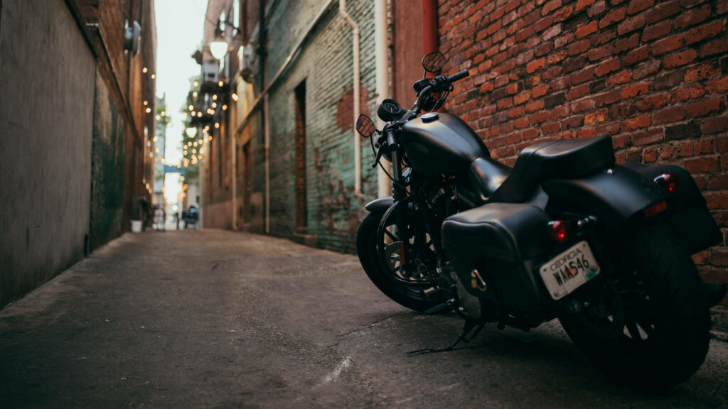 Midnight Cruiser: A Striking 4k Snapshot of a Sleek Black Motorcycle in Urban Shadows Wallpaper
