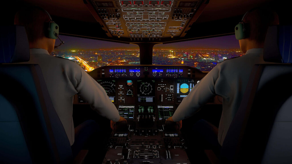 Nighttime airplane cockpit view with illuminated controls pilots and vibrant glowing cityscape below Wallpaper