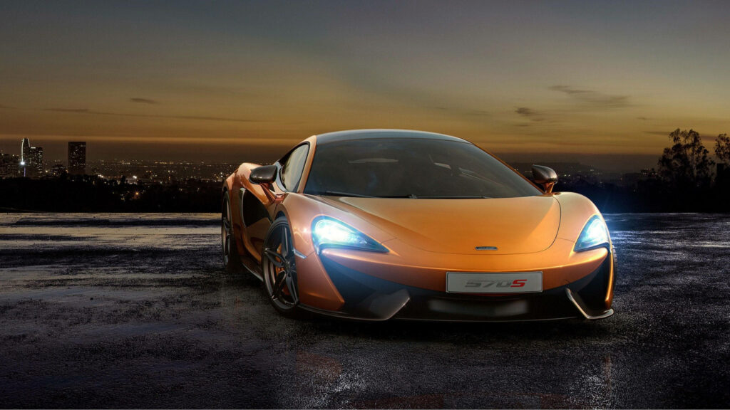 Nightfall Brilliance: The Stunning Orange McLaren 570S Against a Cityscape Backdrop Wallpaper