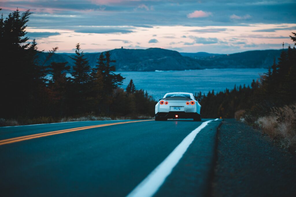 Nissan GT-R at Dusk: Scenic Wallpaper with Trees & Water Views