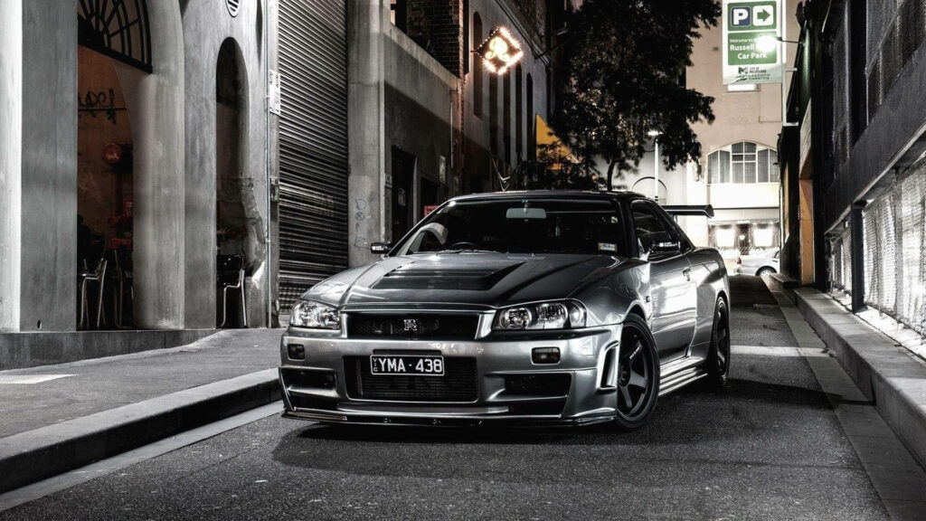 Nissan GT R34 parked on empty city street at night showcasing aggressive sporty design Full HD wallpaper
