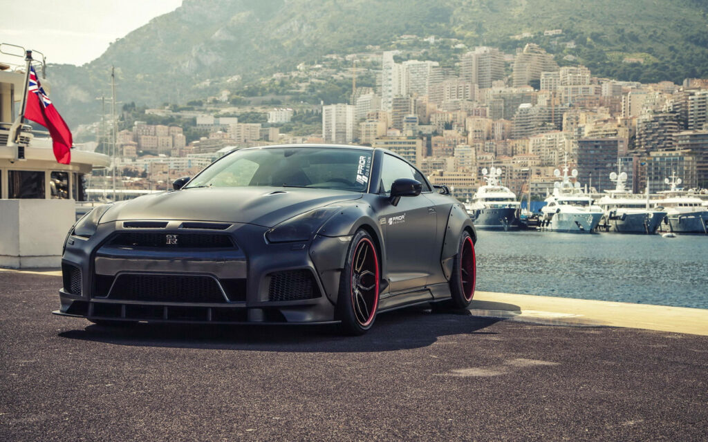Oceanic Dreams: Slick Black Nissan GTR Car against Majestic Oceanscape Wallpaper