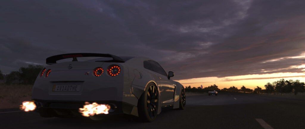 Nissan GT-R racing at sunset with flames from exhaust on open highway Forza gaming wallpaper