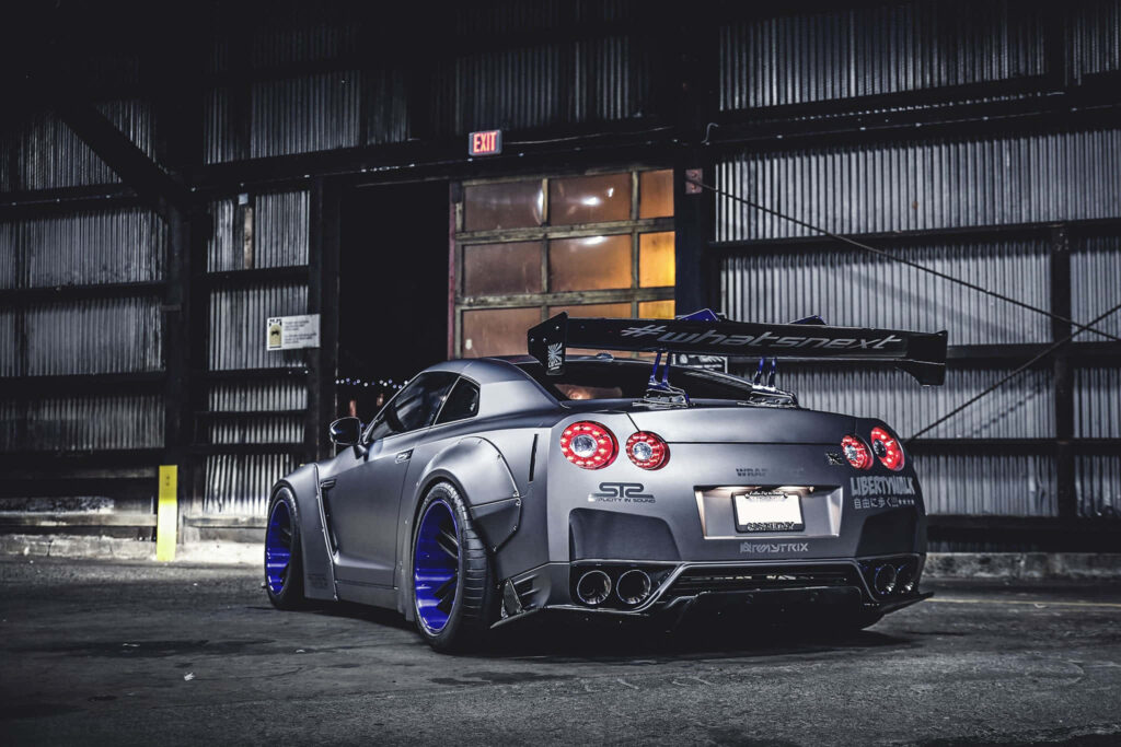 Nissan R35 GTR with Liberty Walk body kit and custom wheels in industrial setting wallpaper