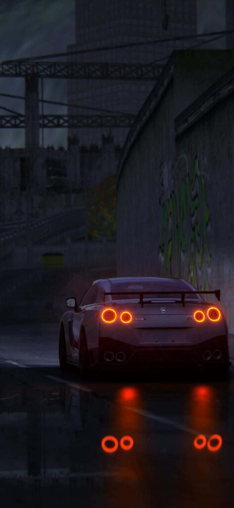 Nissan R35 GTR cruising dark urban street at night glowing taillights wet pavement cityscape Wallpaper
