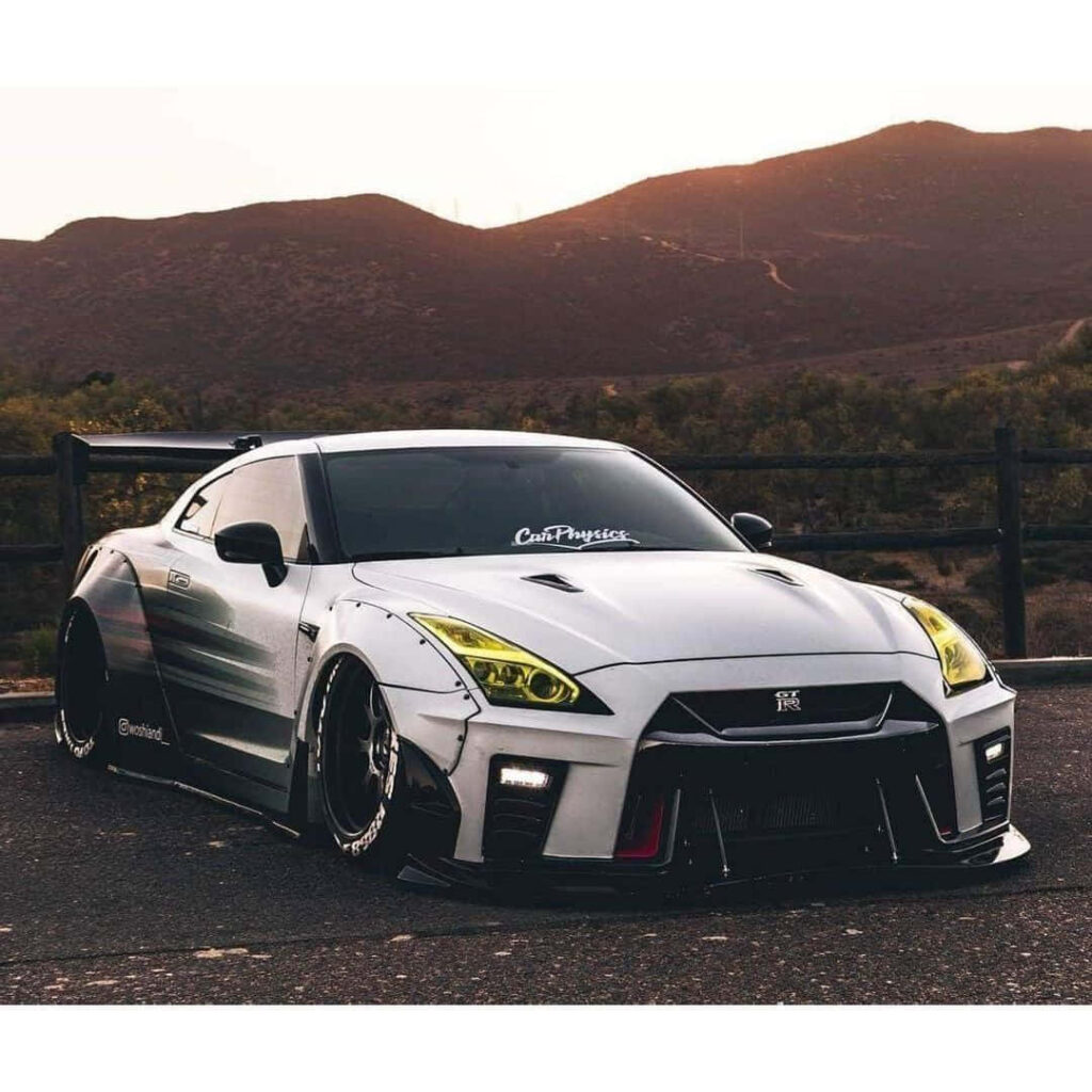 Nissan R35 GTR parked by scenic mountains showcasing aggressive stance and sleek design Wallpaper
