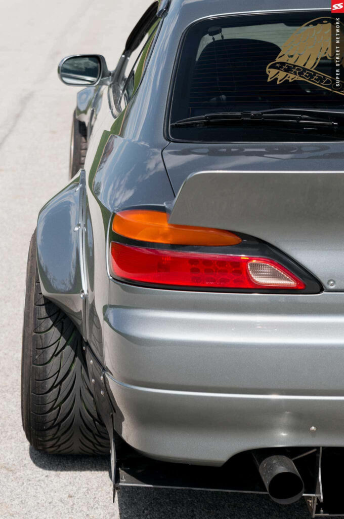 Rear view of silver Nissan Silvia S15 widebody with aggressive wing and sporty custom mods wallpaper