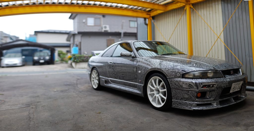 Nissan Skyline GT-R R33 with detailed monochrome wrap parked under yellow carport JDM tuner car Wallpaper