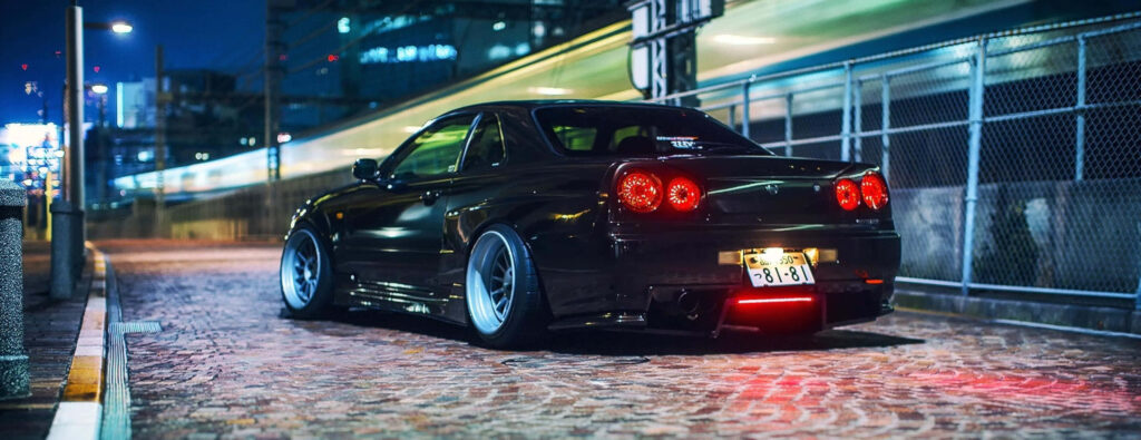 Nighttime Nissan Skyline R33 GT-R Wallpaper with Urban Vibes
