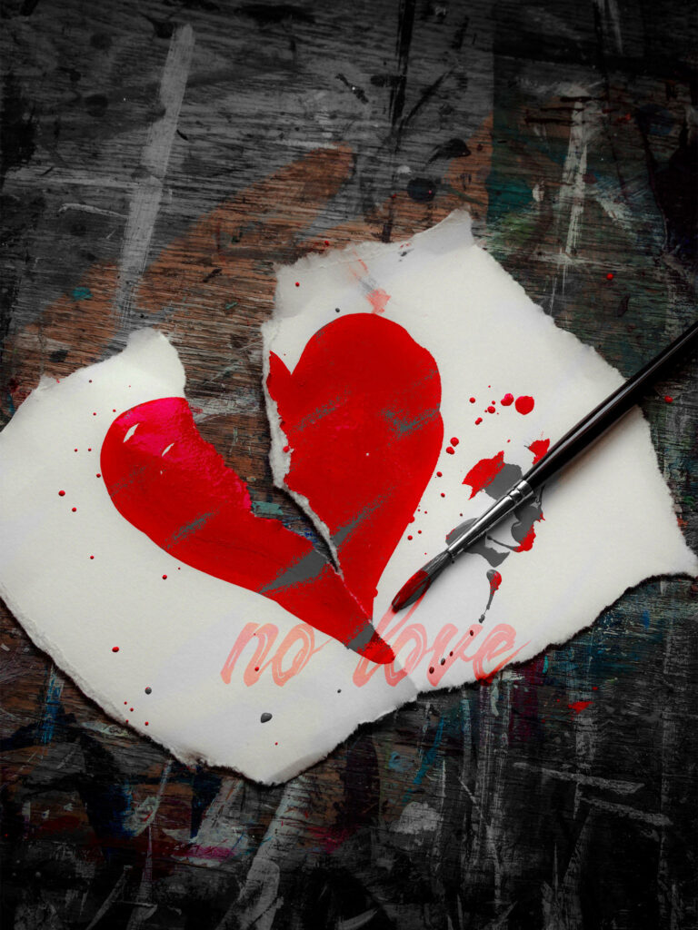 No love painted broken heart on torn paper with red paint splatters dark textured background Wallpaper