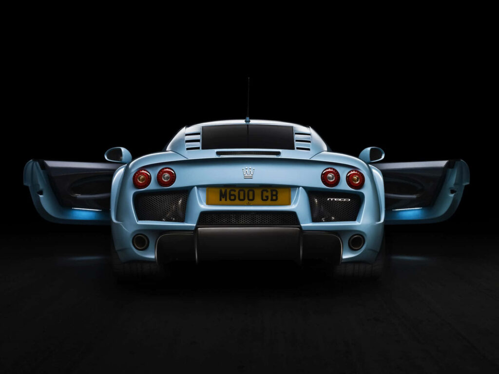 Rear view of Noble M600 supercar with open doors twin exhausts on sleek black background wallpaper