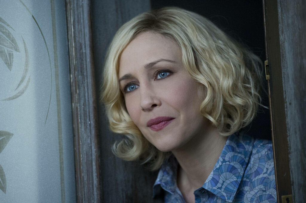 Norma Bates from Bates Motel contemplative closeup by window soft light blonde hair blue blouse wallpaper