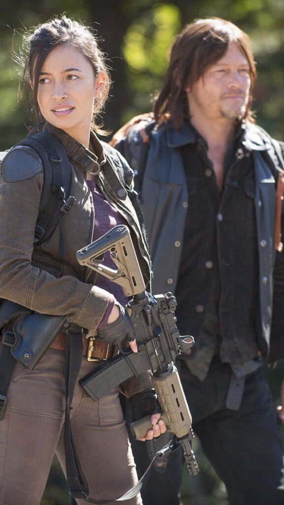 Norman Reedus and Christian Serratos from The Walking Dead in rugged outdoor survival gear Wallpaper