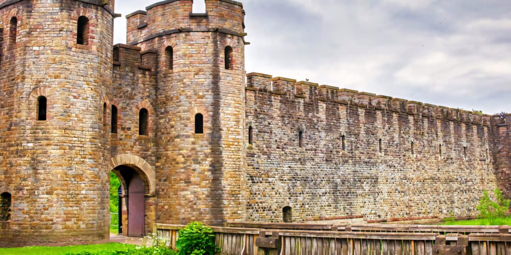 North Gate of Cardiff Castle medieval stone walls under moody sky with lush green surroundings wallpaper
