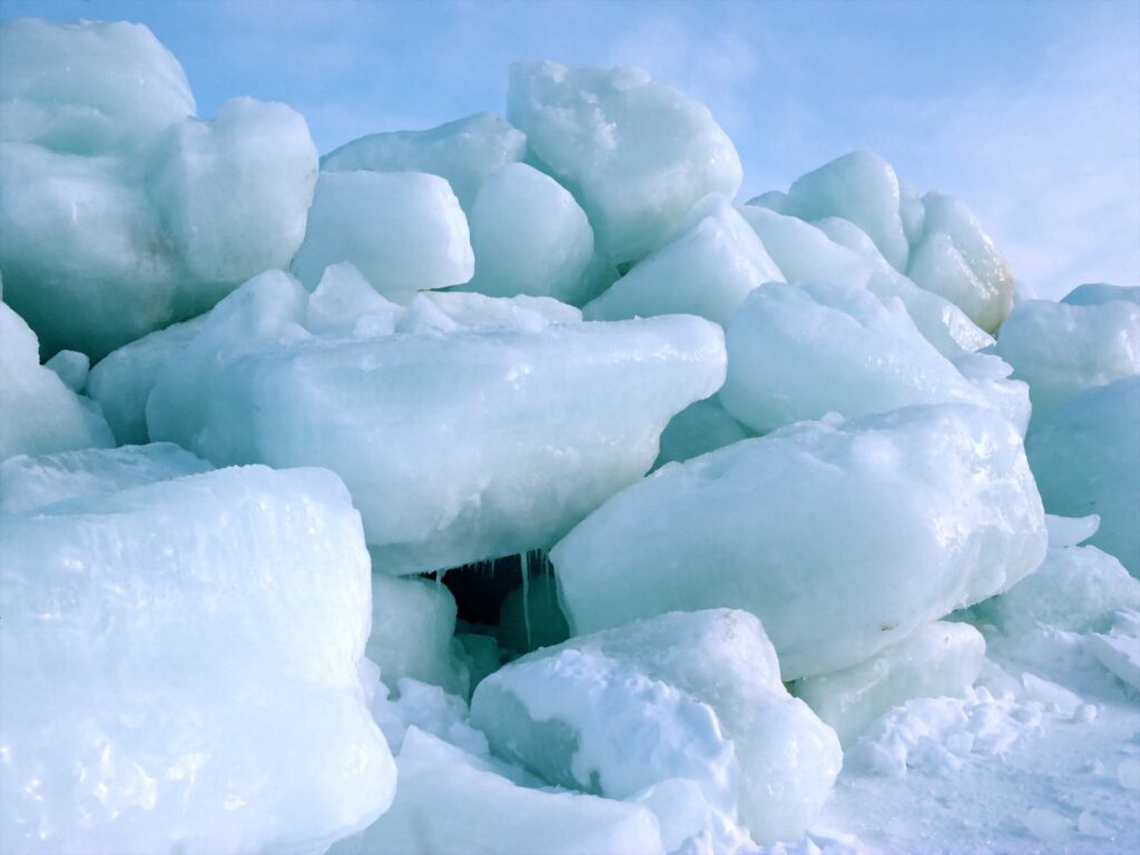 Massive ice blocks stacked under blue sky showcasing North Pole frozen landscape winter wallpaper