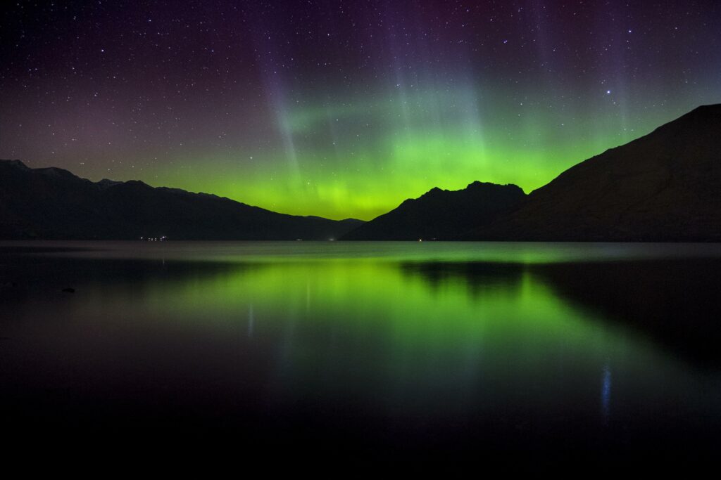 Northern lights over New Zealand mountains reflected in lake vibrant aurora night sky wallpaper