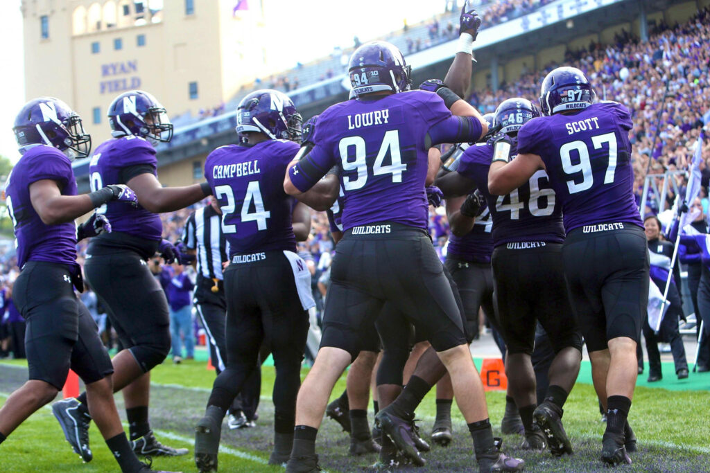 Unity and Spirit: Northwestern Wildcats Football Players Celebration Wallpaper