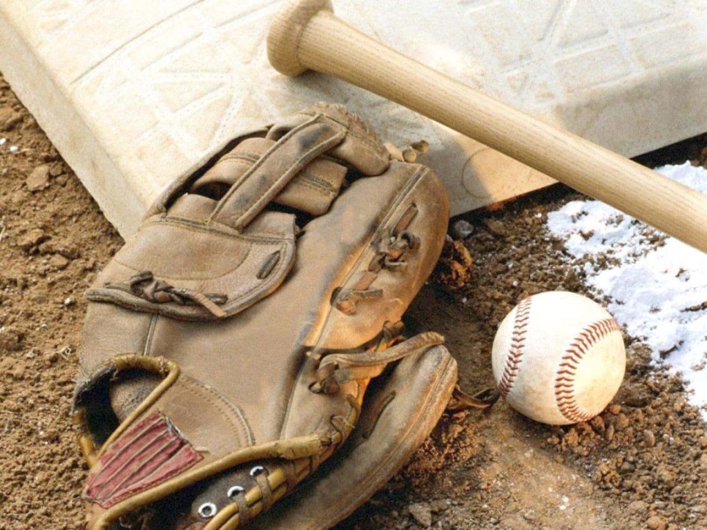 Worn leather baseball glove bat and ball on snowy dirt field near base nostalgic sports wallpaper