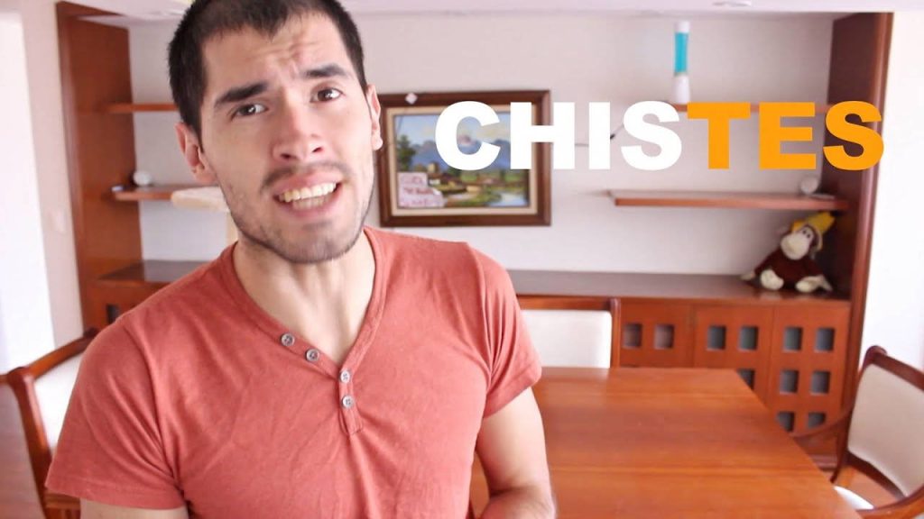 HolaSoyGerman in salmon henley with bold CHISTES text on warm wooden home background Wallpaper