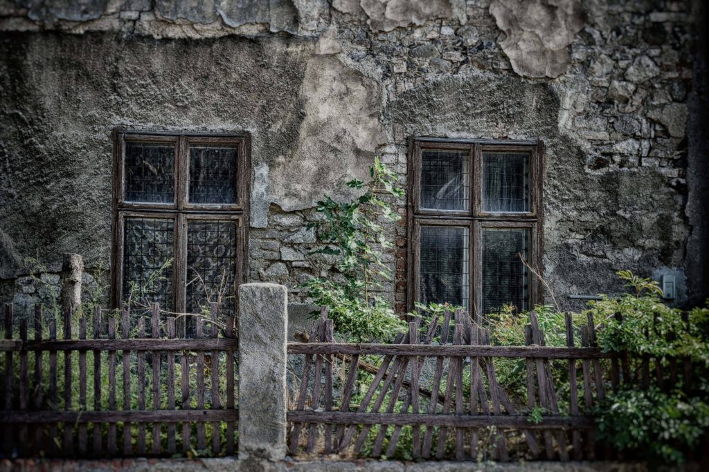 Nostalgic vintage wooden windows on cracked concrete wall with rustic wooden fence backdrop Wallpaper