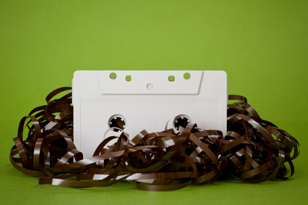 Retro Music Wallpaper: White Cassette on Green with Tangled Tape