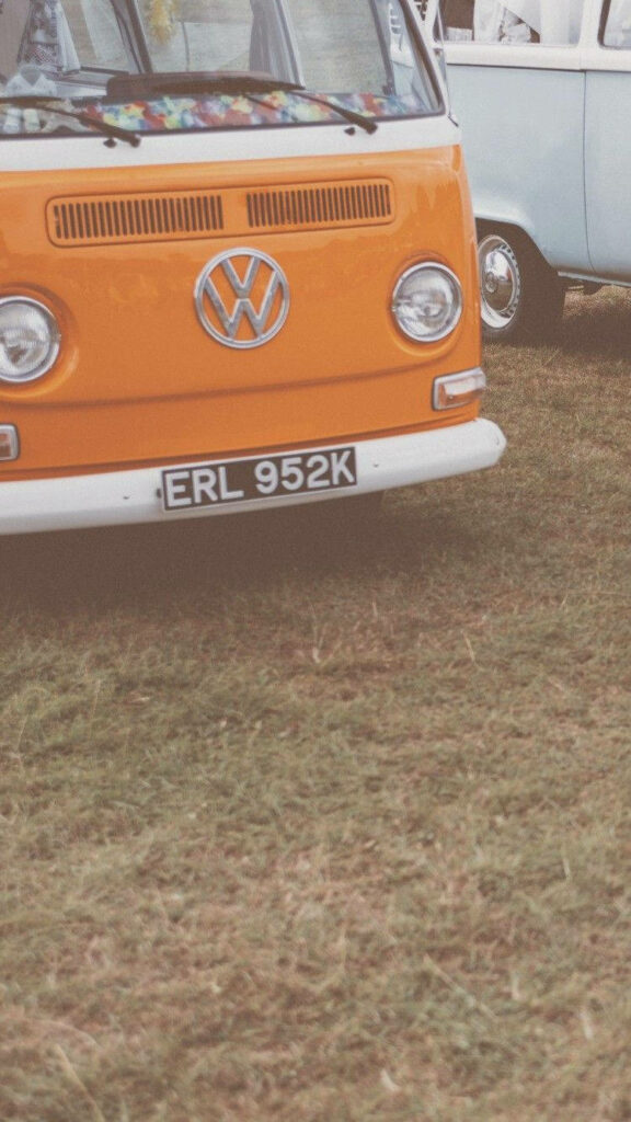 Retro Ride: Aesthetic 90s Yellow Vehicle Posed on a Verdant Grass Field Wallpaper