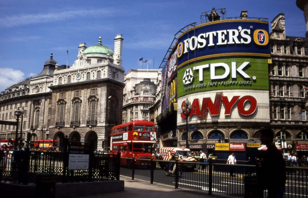 Nostalgic Wallpaper: Vintage Bus at Piccadilly Circus with Classic Ads