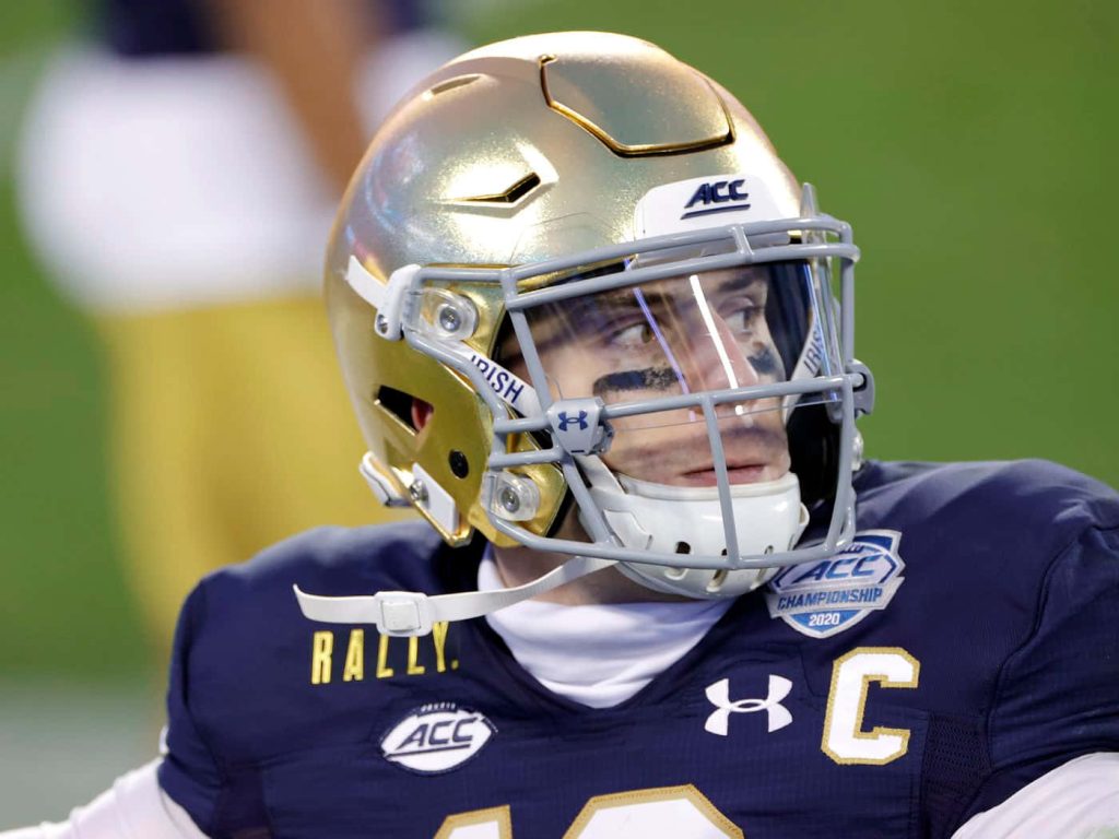 Notre Dame quarterback Ian Book in gold helmet and navy uniform at 2020 ACC Championship game Wallpaper