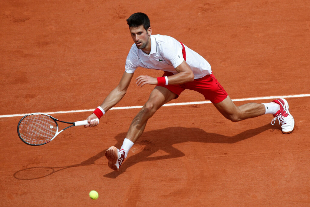 Novak Djokovic in Action: Athleticism & Focus at French Open Wallpaper