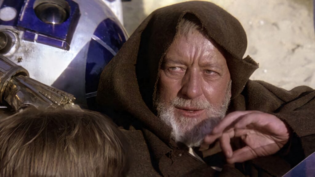 Alec Guinness as Obi-Wan Kenobi in brown robe with R2-D2 in classic sci-fi wallpaper background