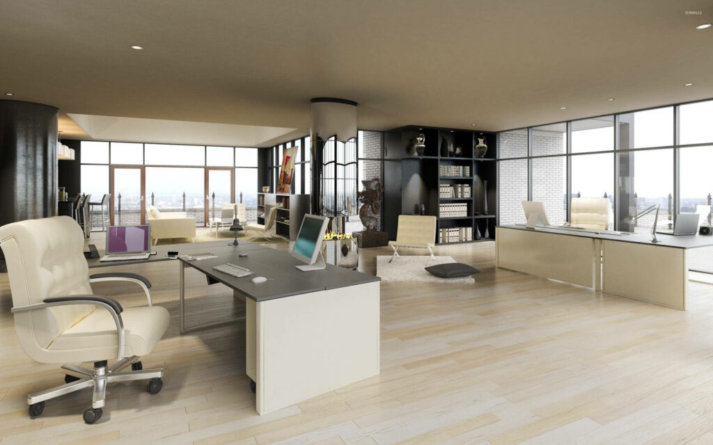 The epitome of a modern and organized workspace - An awe-inspiring sight featuring beige office decor, workstations, ergonomic chairs, sleek monitors, and library-style cabinets Wallpaper